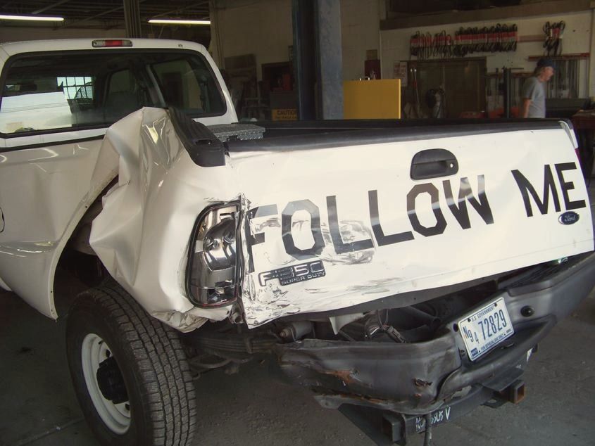 White Ford F-250 with a smashed rear quarter and tailgate