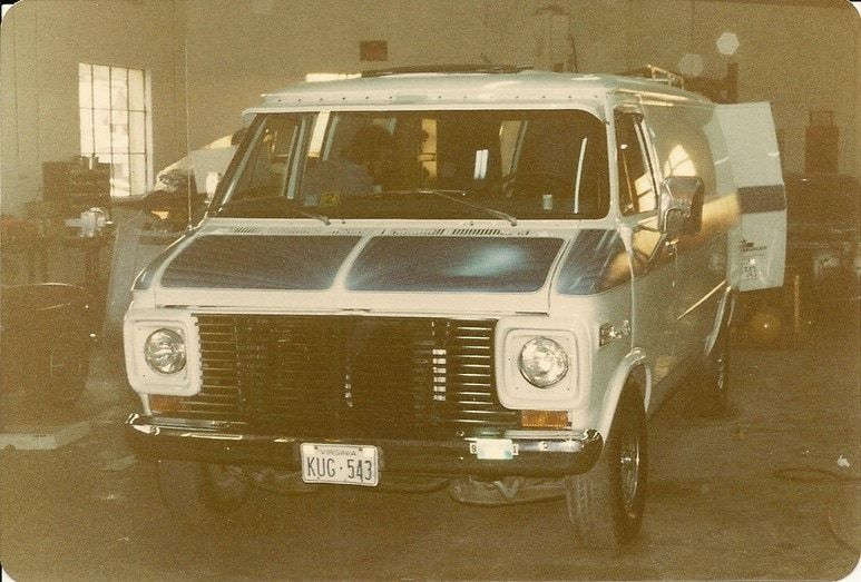 An old photo of the same white van repaired, inside the shop bay