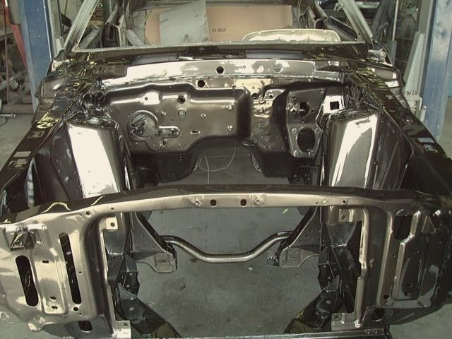Stripped front structure of a 1969 Ford Mustang in the shop