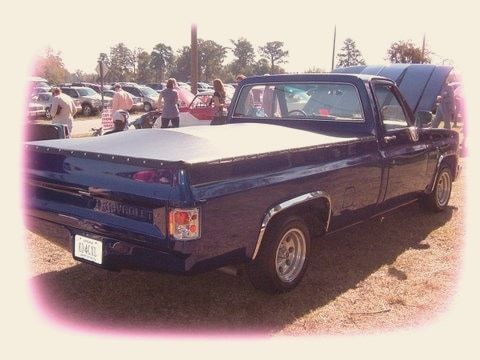 The finished blue pickup at a car show with the hood up
