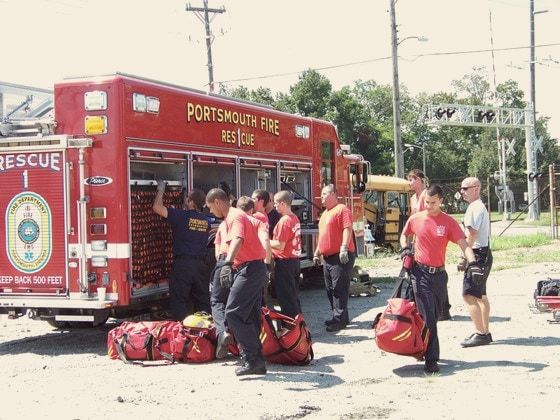 A Portsmouth Fire Rescue crew unloading gear beside their truck